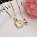 Close-up of gold-plated square pendant necklace with shell letter O and zirconia - Letter O