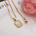 Detailed macro view of a gold-plated square pendant with initial P and shell inlay - Letter P
