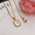 Close-up of gold square pendant with shell inlay and zircon-set letter Z detail. - Letter Z