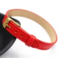 Elegant red leather strap bracelet 10mm width with a gold buckle resting on a black dish - Style 1 / Red