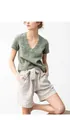 Gros plan d'une femme portant un t-shirt en lin vert à col en V et un short beige. - S / Hauts / Vert clair