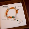 Vintage ethnic agate and bone beaded bracelet with silver Buddha and butterfly charms - Wealth and Protection Buddha / Orange-Yellow