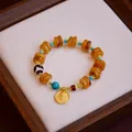 Handcrafted vintage ethnic dZi bead bracelet featuring a Yellow Jambhala deity pendant - Round Plate Yellow Jambhala Imitation Amber / Amber