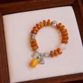 Retro ethnic style amber agate bracelet with silver charms and 12mm quartz bead - Conch Fortune Bag Style / Yellow
