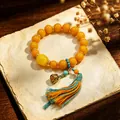 Vintage ethnic yellow bead bracelet with cloisonné lotus charm and tassel - Cloisonne Lotus Pod with Blue & Yellow Tassel / 12mm Bead Diameter / Chicken Fat Yellow