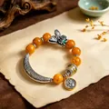 Ethnic style bracelet with faux beeswax beads, butterfly and Zhajilamu charms. - Curved Tube: Butterfly Amulet Fortune Bracelet