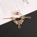 Macro detail of vintage gold-tone moth and crescent moon hairpin with purple gemstones. - Antique Gold