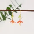 Handmade red mushroom resin drop earrings with green leaf and white flower charms - Red Mushroom Style (FN1004)