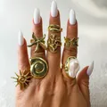 Gros plan de bagues vintage dorées avec perle irrégulière et motifs marins sur main. - Style Perle Artificielle Océan Vintage Or de 8 Pièces (33459-ring-G)
