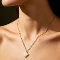 Elegante collar de cadena de bolas dorada con un colgante de trébol de cuatro hojas blanco. - Cadena Dorada con Trébol (NS-0085)