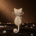 Vista detallada de un broche de gato dorado con cristales pavé y un lazo plateado - Gato plateado