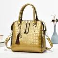 Detailed macro view of golden patent leather handbag with crocodile skin texture - Gold