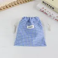 Close-up of a blue gingham drawstring storage bag perfect for cosmetics or travel. - Navy Plaid