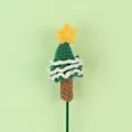 Macro view showing the detailed texture of a handmade green crochet Christmas tree ornament - Star Christmas Tree Stem / Green