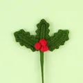 Detailed view of hand-knitted crochet holly branch with red berries for Christmas decor. - Red Berry Stem / Dark Green