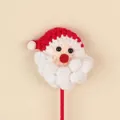 Detail view of a handmade crochet Santa Claus head ornament for holiday bouquets - Santa Head Stem (Red Hat) / Red Stem