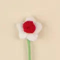 Detailed macro shot of a handmade red and white crochet flower decoration with stem - Christmas Puff Flower (White Petal Red Stamen) / Red And White