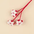 Detail view of a handmade red and white wool knitted flower branch for Christmas decor - Large Cotton Branch / Red