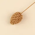 Close-up detail of a handmade brown wool knitted pinecone for Christmas decorations - Pine Cone Stem / Tan