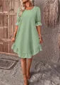 Full view of green cotton linen dress featuring ruffle hem and mid-sleeves in rustic setting - S / Dresses / Emerald Green