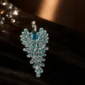 Primer plano de un broche de pavo real plateado con brillantes pedrería turquesa. - Broche de Pavo Real / Plata Azul Claro
