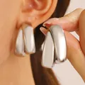Minimalist silver interlocking double loop earrings with a smooth metallic finish. - Interlocking Double Ring Style / White K/Silver
