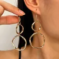 Minimalist large golden double hoop irregular geometric dangle earrings on model - Geometric Double Ring Style / KC Gold