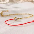 Nahaufnahme eines roten Stoffarmbands im chinesischen Stil mit Zirkonia-Anhänger - Strass Fußkettchen (A98)