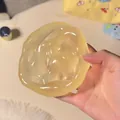 Translucent yellowish maltose squishy toy for stress relief shown being squeezed in hand - 椰子黄油款 / 6cm Size / Translucent Pale Yellow