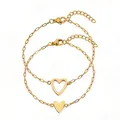 Vue détaillée de deux bracelets cœur en acier inoxydable doré sur fond blanc - Combinaison de Cœurs Creux et Pleins / Ensemble deux pièces / Or