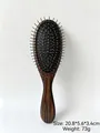 Close-up detail of a portable air cushion massage hair brush with silver needle pins. - Dark Brown