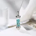 Detalle de un colgante cilíndrico plateado con piedras de turquesa y grabado « Love » - Turquesa