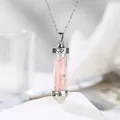 Close-up detail of a hexagonal silver pendant filled with pink rose quartz and Love engraving - Rose Quartz