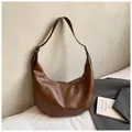 Vollansicht einer braunen Vintage-Tasche in einem minimalistischen Schlafzimmer - Braun