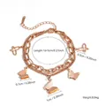 Bracelet double couche en acier titane or rose avec breloques papillon givrées - Or rose