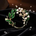 Close-up of elegant floral wreath brooch with green enamel leaves and pearls. - Enamel Gardenia Style (Enamel Gardenia Brooch)