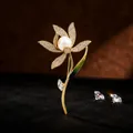 Macro view of gold-toned flower brooch with crystals, pearl, and green enamel leaf - Daffodil Style (Daffodil Brooch)