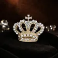 Elegant gold-tone crown brooch with shimmering rhinestones for women's apparel. - Gold