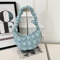 Detail view of a light blue ruched bubble dumpling bag on a stylish display stand - Light Blue