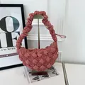 Close-up of dusty rose bubble textured cloud bag on a display stand. - Dusty Pink