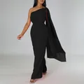 Full-length shot of an elegant black one-shoulder jumpsuit with a long flowing cape sleeve - S / Set / Black