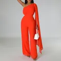 Detailed view of the elegant orange one-shoulder jumpsuit with a long flowing side cape - Orange Red