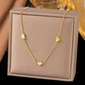 Detailed close-up view of a gold heart pendant necklace on a beige jewelry display box. - Three Hearts (H1193)