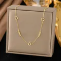 Elegant gold-tone necklace with hollow clover charms and gold beads on a grey display box. - Gold Bead Hollow Clover (H1196)