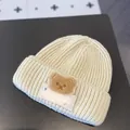 Cozy cream infant knit beanie featuring a cute plush bear patch for winter warmth. - One Size / Luck Bear Style / Off White