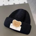 Cozy black baby winter beanie hat featuring a cute brown plush teddy bear patch decoration - One Size / Luck Bear Style / Black