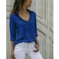 Detail shot of a vibrant blue button-down shirt styled with white pants and jewelry - S / Tops / Dark Blue
