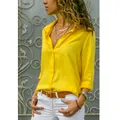 Vista lateral detallada de una blusa abotonada amarilla de manga larga con accesorios dorados - Amarillo