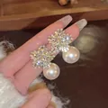 Elegant snowflake design pearl drop earrings featuring sparkling cubic zirconia stones - Gold