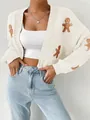Vue détaillée d'un cardigan blanc tricoté avec motif brodé d'homme en pain d'épice - S / Hauts / Abricot